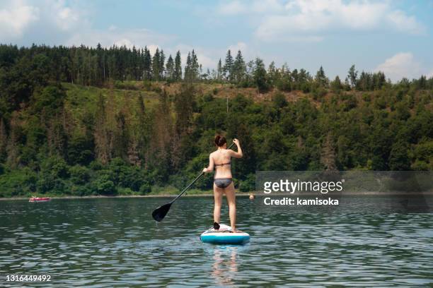 teenage mädchen auf stand up paddleboard - season 15 stock-fotos und bilder