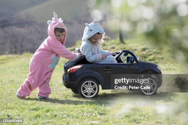 children playing with ride in toy car - riding unicorn stock pictures, royalty-free photos & images