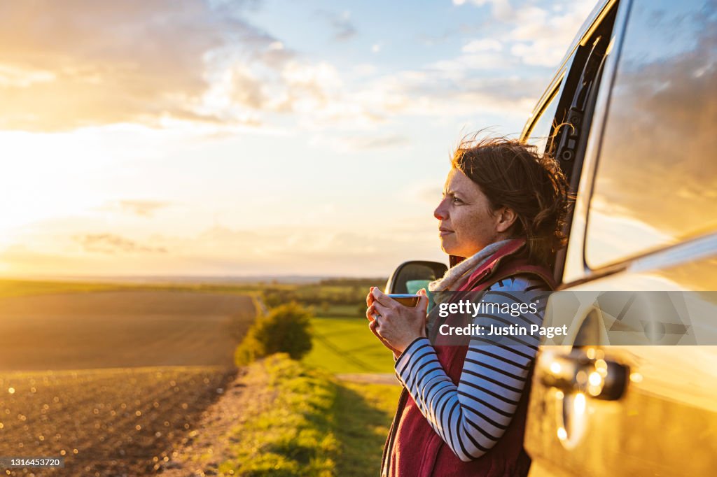 Woman looking at the view from her campervan