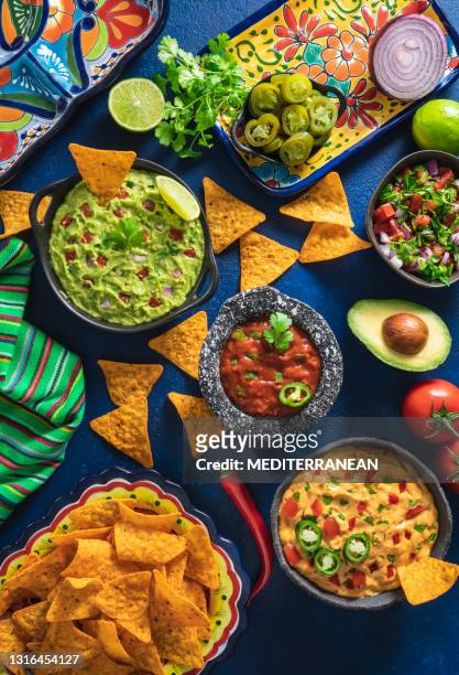 mexican dip sauces guacamole, cheedar dip, tomato salsa and pico de gallo with nacho chips - méxico stock pictures, royalty-free photos & images