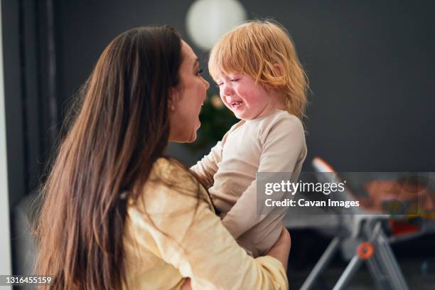 woman trying to calm her son who is crying - tears happiness stock pictures, royalty-free photos & images