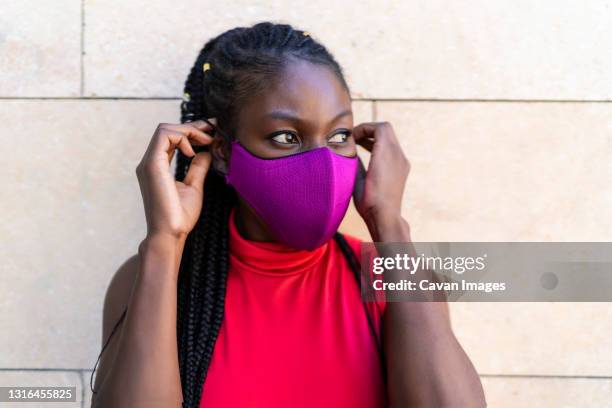 african woman athlete putting on the mask - lateral portrait looking mobile photos et images de collection