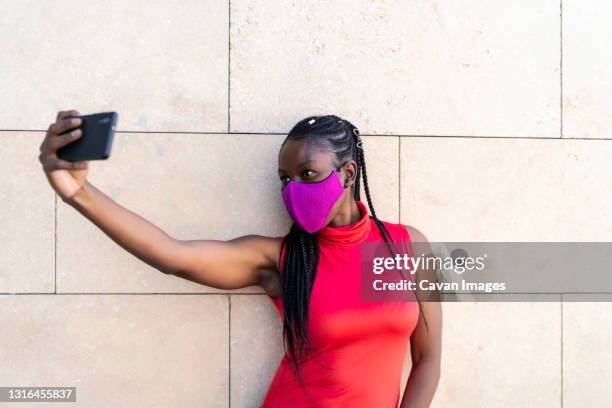 african woman athlete taking a photo from her smartphone - lateral portrait looking mobile photos et images de collection