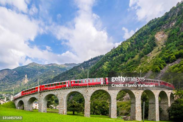 switzerland, red train on the brusio spiral viaduct - brusio grisons stock pictures, royalty-free photos & images