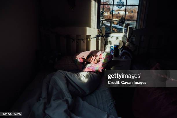 young girls waking up with sun in her eyes - auto sofa stock pictures, royalty-free photos & images