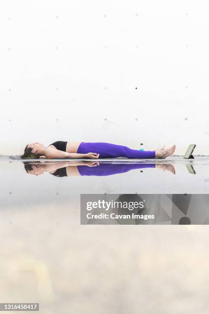 athlete woman doing the savasana posture during an online yoga class - savasana stock pictures, royalty-free photos & images