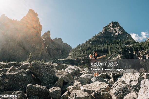 father hiking with his young daughter in a carrier - rocky point stock pictures, royalty-free photos & images