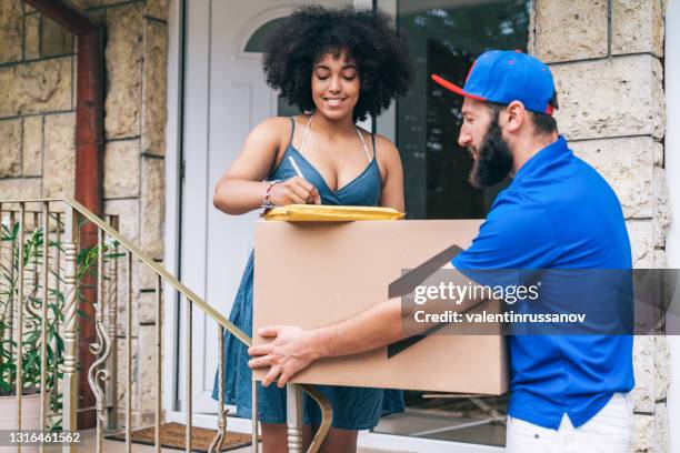 african woman receiving a delivery.deliveryman carry big box deliver to customer in front of door at home. - chubby man shopping stock pictures, royalty-free photos & images