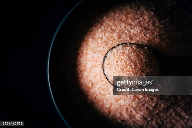 photograph of himalayan salt grains. - himalayan salt stock pictures, royalty-free photos & images