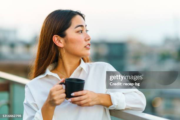 バルコニーでマグカップを持っている美しい女性の肖像画 - tea outdoor ストックフォトと画像