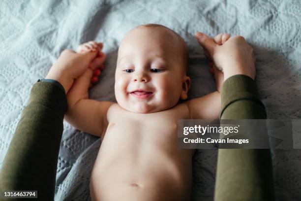 smiling baby while morning physical exercises - son massage mom imagens e fotografias de stock