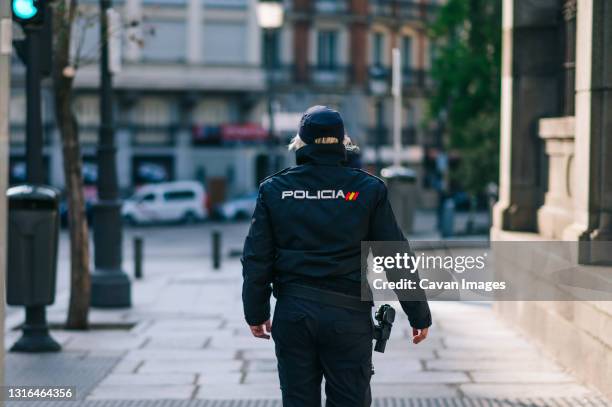 policewoman member of the spanish security forces and bodies walking down a city street - força policial imagens e fotografias de stock