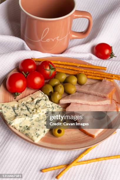 plate with snacks and a cup on a white napkin - gorgonzola stockfoto's en -beelden