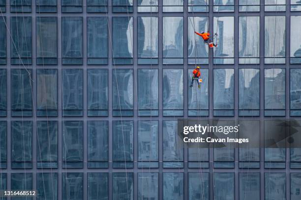 window cleaner's working on facade of high rise building in bangkok - fönsterputsare bildbanksfoton och bilder