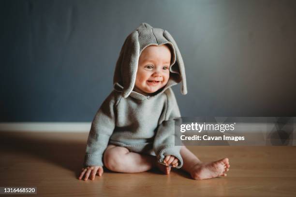 adorable smiling baby wearing a bunny costume to celebrate easter - tierkostüm stock-fotos und bilder