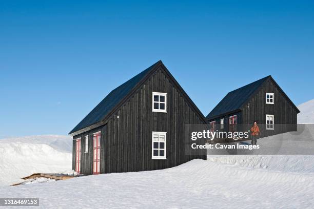 woman setting off for a hike from ski cottage in iceland - house remote location stock pictures, royalty-free photos & images