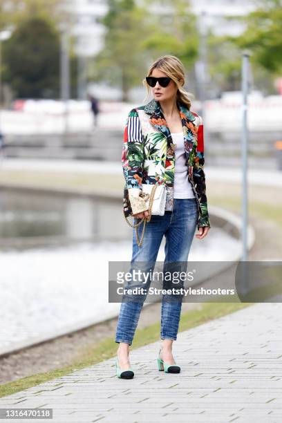 Influencer Gitta Banko wearing a multicolor blazer with different floral design by Dolce & Gabbana, a white tank top with gold logo by Dolce &...