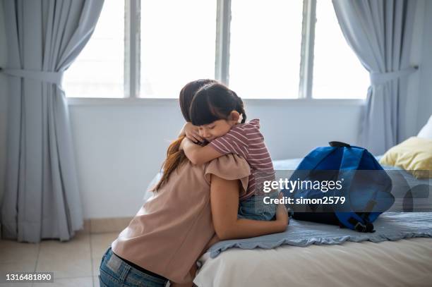 girl hugs her mother on first day of school - first day school hug stock pictures, royalty-free photos & images