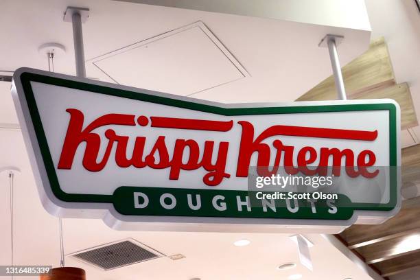 Sign featuring the company logo hangs at the entrance of a Krispy Kreme store on May 05, 2021 in Chicago, Illinois. The doughnut chain reported...