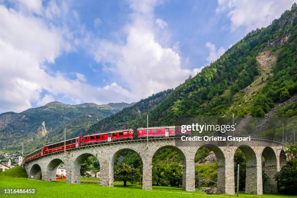 red train on the brusio spiral viaduct,switzerland - brusio grisons stock pictures, royalty-free photos & images