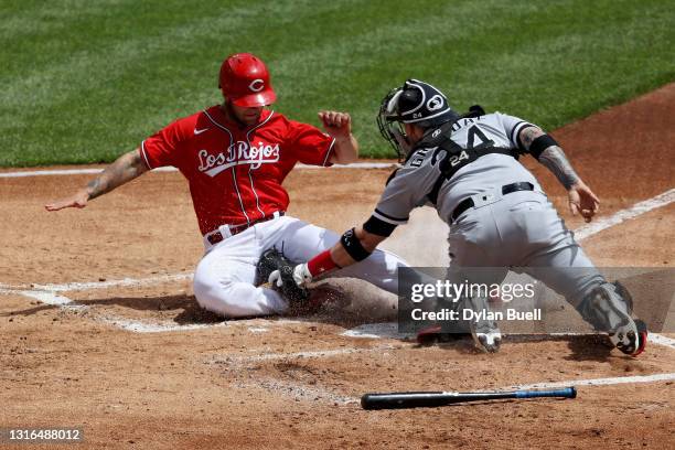 Yasmani Grandal of the Chicago White Sox tags out Nick Senzel of the Cincinnati Reds at home plate in the first inning at Great American Ball Park on...