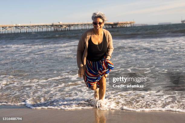 reife schwarze frau am strand - african american women wet stock-fotos und bilder