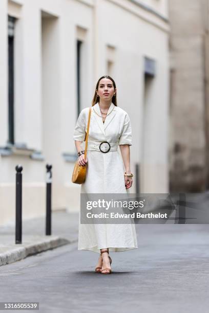 Maria Rosaria Rizzo @lacoquetteitalienne wears gold earrings, a gold chain necklace, a gold chain pendant necklace, a white blazer collar rolled-up...