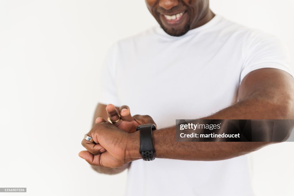 Uomo maturo che guarda il suo orologio da allenamento a casa.