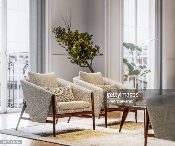 stylish armchairs in brightly lit living room - armchair stock pictures, royalty-free photos & images