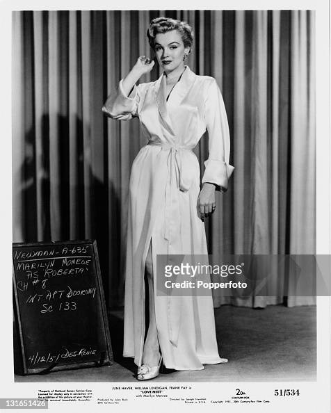 American actress Marilyn Monroe wearing a satin robe in a promotional ...