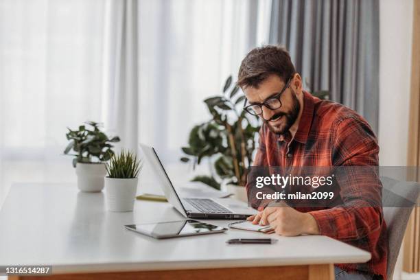 young man working from home - red dress shirt stock pictures, royalty-free photos & images
