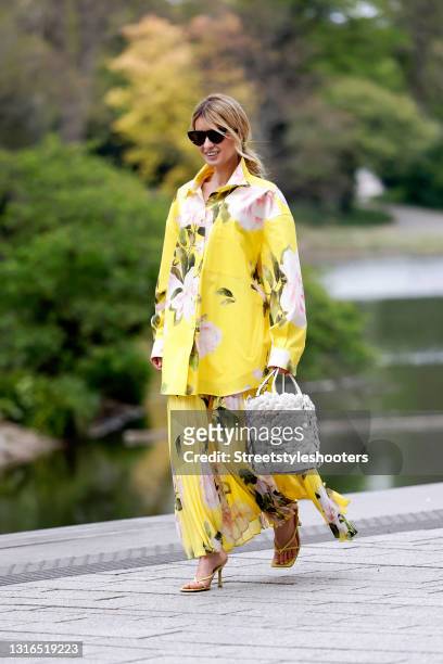 Influencer Gitta Banko wearing a braid hairstyle, a yellow floral print blouse by Valentino, a long yellow pleated floral print skirt by Valentino, a...