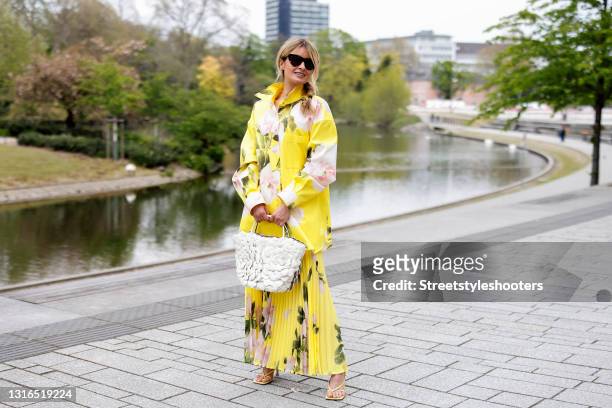 Influencer Gitta Banko wearing a braid hairstyle, a yellow floral print blouse by Valentino, a long yellow pleated floral print skirt by Valentino, a...