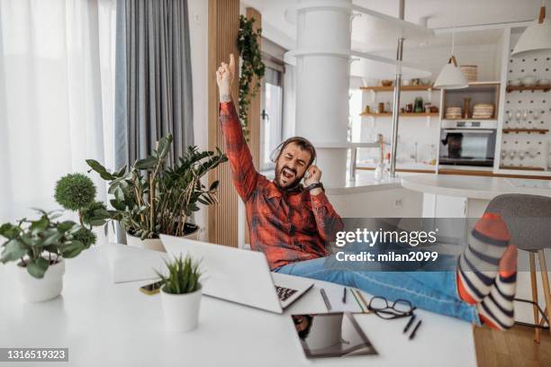 young man working from home - red dress shirt stock pictures, royalty-free photos & images