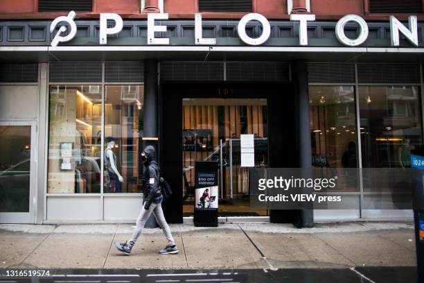 New York - NEW YORK A woman walks in front of a Peloton store in Manhattan on May 05, 2021 in New York. Peloton company has recalled both of its...