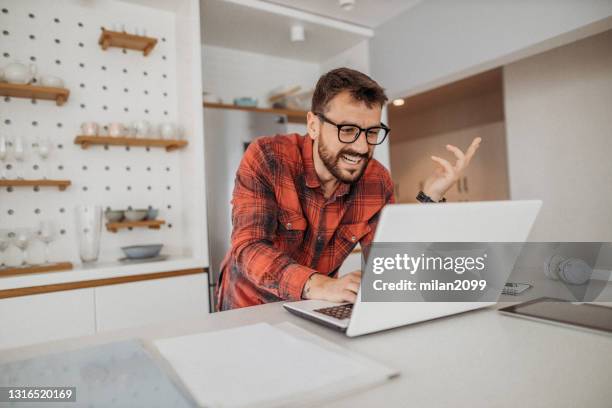 young man working from home - red dress shirt stock pictures, royalty-free photos & images