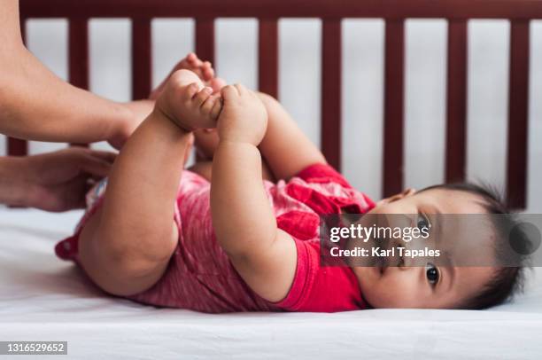 southeast asian baby boy getting dressed - six month old stock pictures, royalty-free photos & images