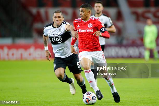Richard Ortiz of Olimpia competes for the ball with Taison of Internacional during a match between Internacional and Olimpia as part of Group B of...