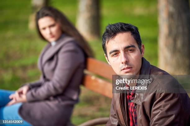 separated young couple in a city park - relationship conflict stock pictures, royalty-free photos & images