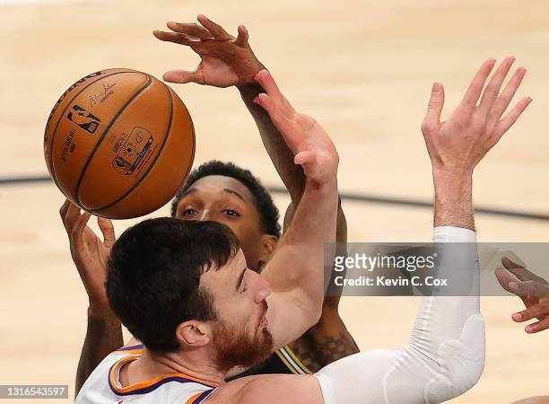 Lou Williams of the Atlanta Hawks has the ball knocked away as he drives against Frank Kaminsky and Jevon Carter of the Phoenix Suns during the...