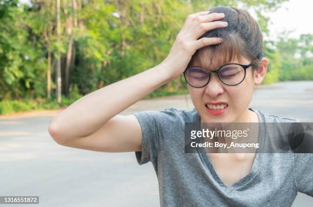 young asian woman having headache. a thunderclap headache is a severe headache that starts suddenly. - body piercings stock pictures, royalty-free photos & images
