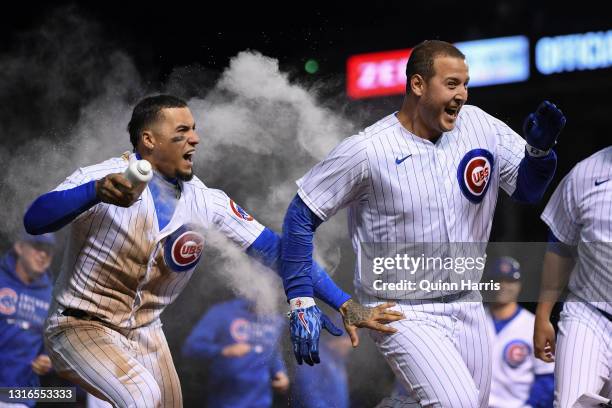 Anthony Rizzo of the Chicago Cubs celebrates his walk off single with Javier Baez and teammates of the Chicago Cubs in the 11th inning against the...