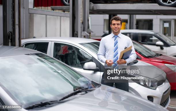 portret van een verkoper die bij de handelaar werkt die auto's in openlucht toont - autoverkoper stockfoto's en -beelden