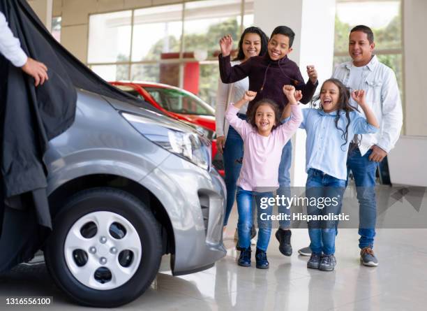 excited family at the dealership unveiling their new car - car launch event stock pictures, royalty-free photos & images