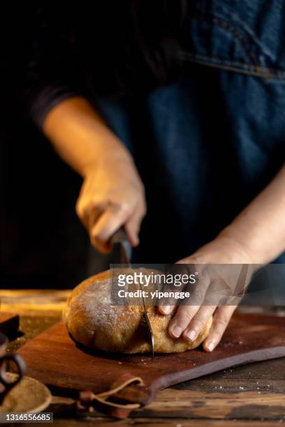 woman cutting rye bread with bread knife - round loaf stock pictures, royalty-free photos & images