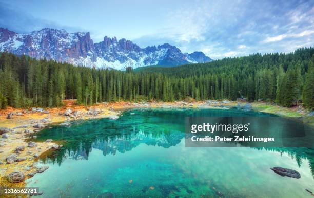 lago di carezza and the latemar mountain range in the background, south tyrol, italy. - lago de carezza fotografías e imágenes de stock