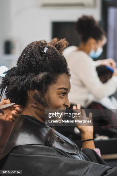 black woman getting her hair cut in a hair salon - adjusting hair stock pictures, royalty-free photos & images