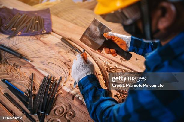 craftsman or carved carpenter wear safety glasses and a helmet "n using gouge wood chisel carpenter tool hand hammer craftsman - feile stock-fotos und bilder