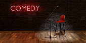 stage with microphone and stool with red neon lamp with the word COMEDY. space for text