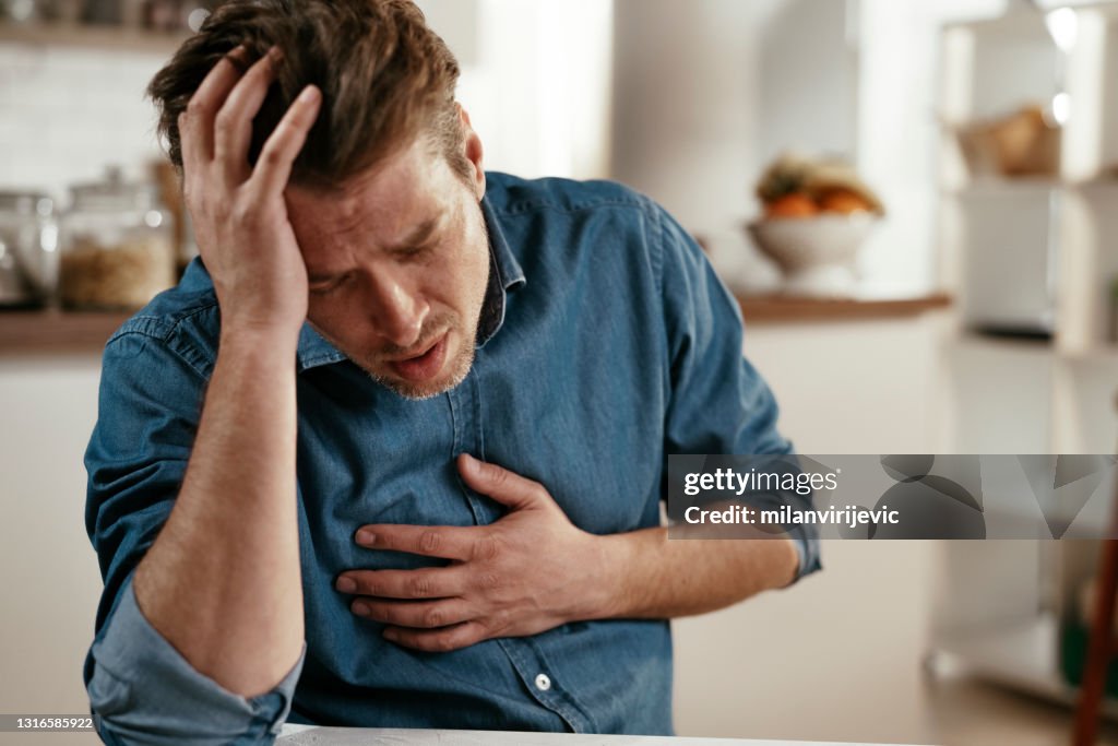 Portrait of man placing hands on the chest suffering from pain in the heart.